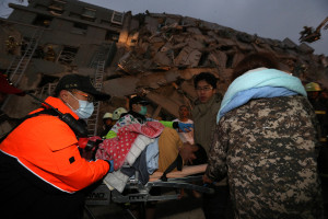 Rescue personnel carry a survivor at the site of a collapsed building in the southern Taiwanese city of Tainan following a strong 6.4-magnitude earthquake that struck the island early on February 6, 2016. At least 30 people have been rescued after four buildings collapsed after a shallow quake struck at a depth of 10 kilometres (six miles) around 2000 GMT Friday, according to the US Geological Survey, 39 kilometres northeast of Kaohsiung, the second-largest city on the island and an important port. / AFP / Johnson Liu (Photo credit should read JOHNSON LIU/AFP/Getty Images)